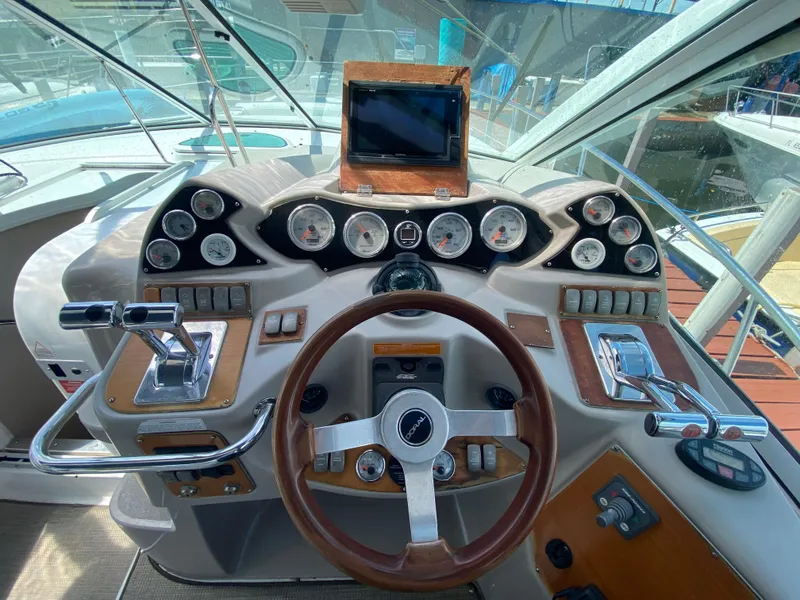 Slide: The Image of 2006 Doral 365 boat dashboard with steering wheel, gauges, and controls. - 31