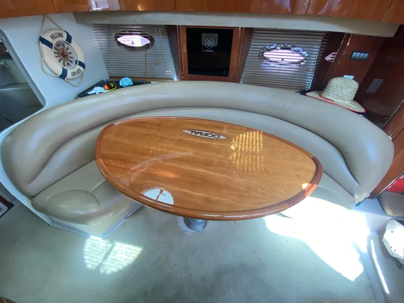 Slide: The Image of Interior of a 2006 Doral 365 boat with a wooden table and leather seating. - 34