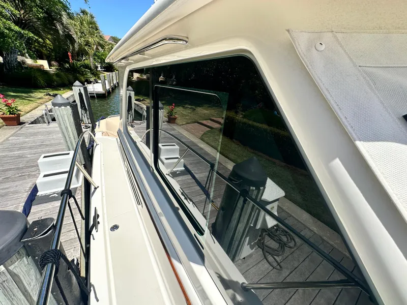 Slide: The Image of 2022 Back Cove 372 yacht docked, showcasing sleek design and reflective windows. - 12