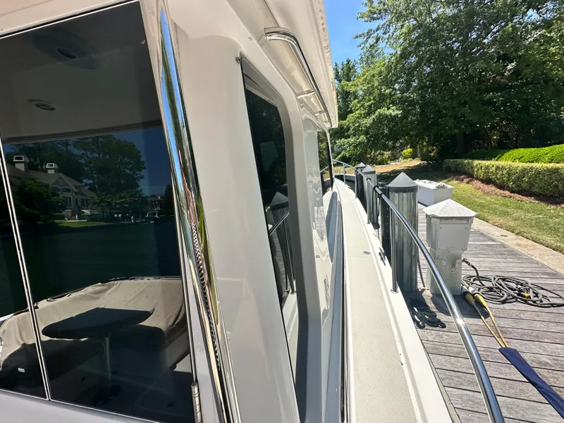 Slide: The Image of 2022 Back Cove 372 yacht docked, showcasing sleek design and reflective windows. - 14