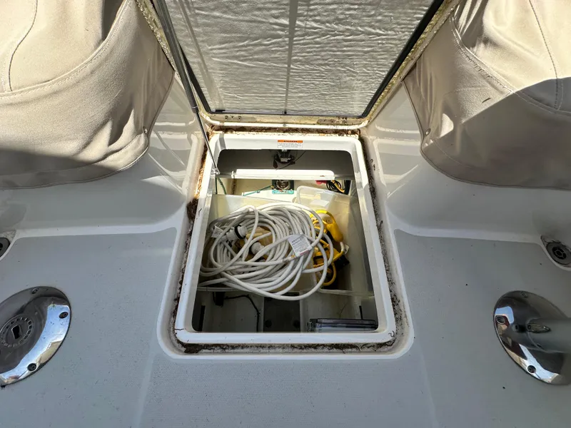Slide: The Image of Open storage compartment on 2022 Back Cove 372 boat, containing coiled cables and equipment. - 15