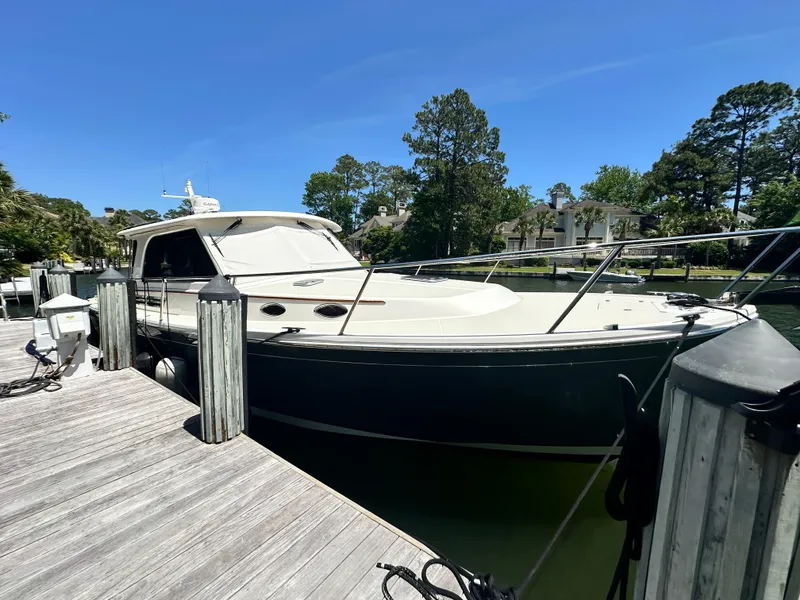 Slide: The Image of 2022 Back Cove 372 boat docked at a marina under clear blue skies. - 21