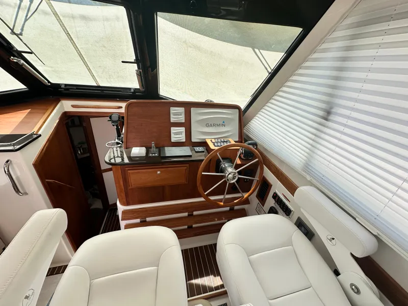 Slide: The Image of 2022 Back Cove 372 helm with Garmin navigation, wooden accents, and white seating. - 27