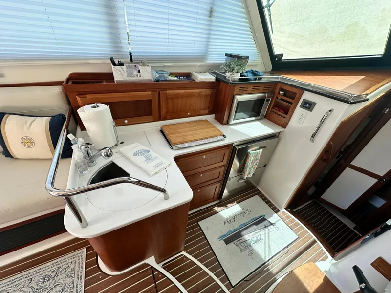 Slide: The Image of 2022 Back Cove 372 yacht interior kitchen with wooden cabinetry and modern appliances. - 28