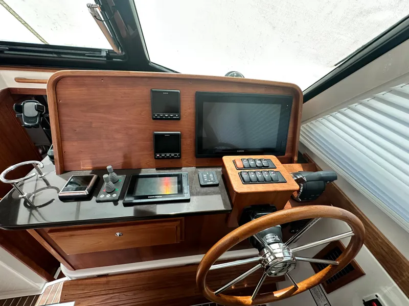 Slide: The Image of 2022 Back Cove 372 helm with wooden wheel, modern controls, and navigation screens. - 30
