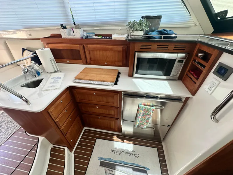Slide: The Image of Modern kitchen in 2022 Back Cove 372 yacht with wooden cabinetry and stainless steel appliances. - 32