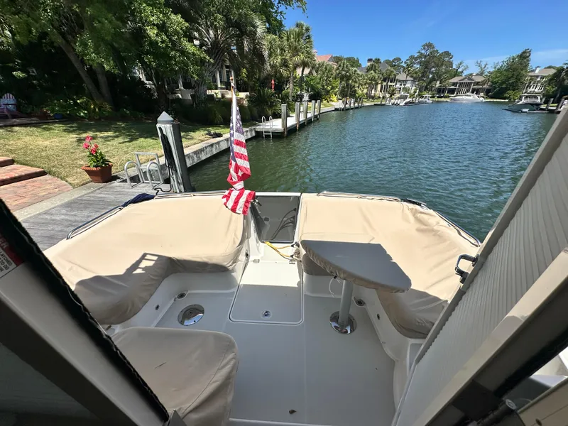 Slide: The Image of 2022 Back Cove 372 boat docked by a scenic waterfront with lush greenery. - 39