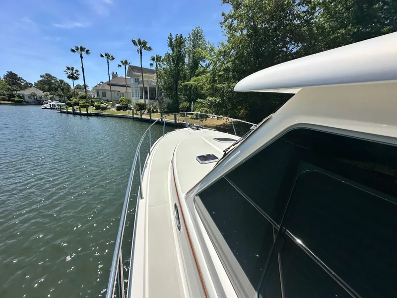 Slide: The Image of 2022 Back Cove 372 yacht cruising near waterfront homes and palm trees. - 42
