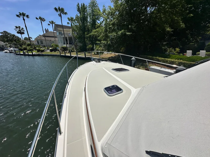 Slide: The Image of 2022 Back Cove 372 boat docked by waterfront homes and palm trees. - 43