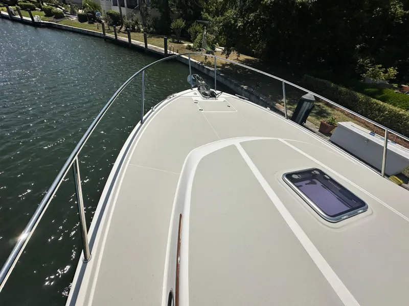 Slide: The Image of 2022 Back Cove 372 boat deck with railing, docked by a canal. - 5