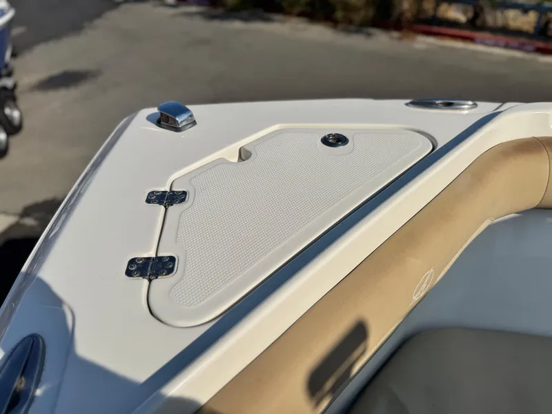 Slide: The Image of 2021 Sailfish 242 CC boat deck detail with storage compartment and beige seating. - 11
