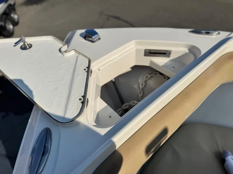 Slide: The Image of Open anchor compartment on 2021 Sailfish 242 CC boat, showing chain storage. - 12