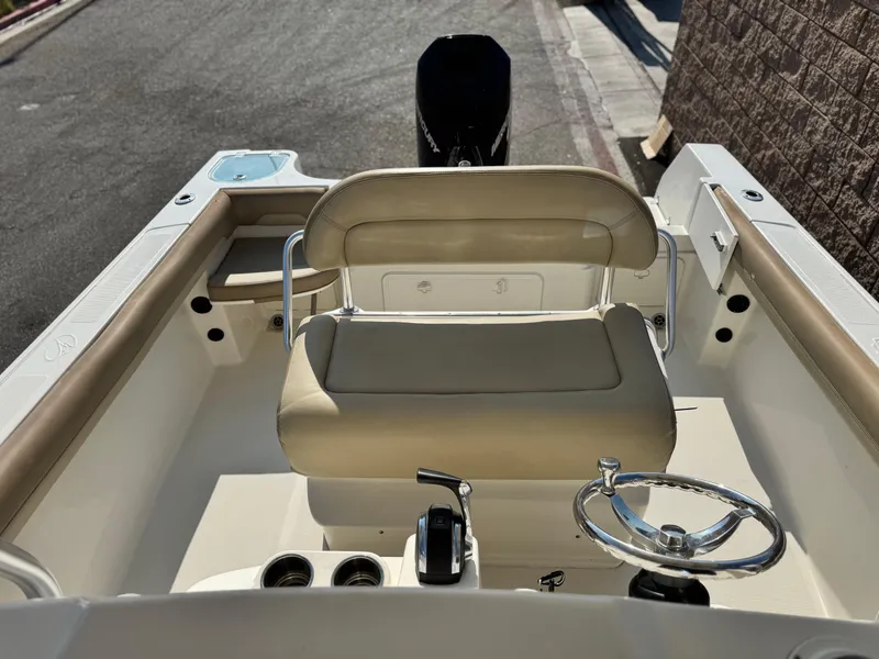 Slide: The Image of 2021 Sailfish 242 CC boat interior with beige seating and steering wheel. - 19