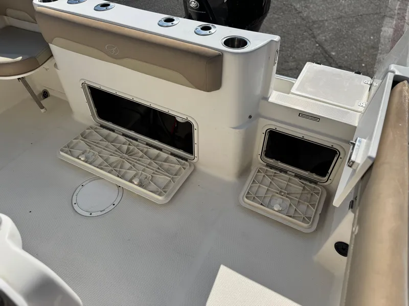 Slide: The Image of 2021 Sailfish 242 CC boat interior with storage compartments and cup holders. - 21