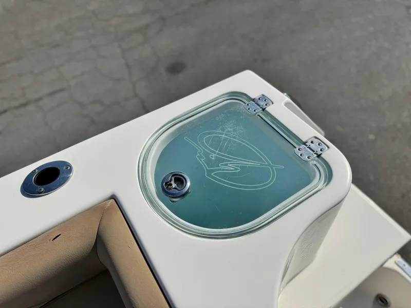Slide: The Image of 2021 Sailfish 242 CC boat livewell with logo, featuring a secure latch and clear lid. - 22