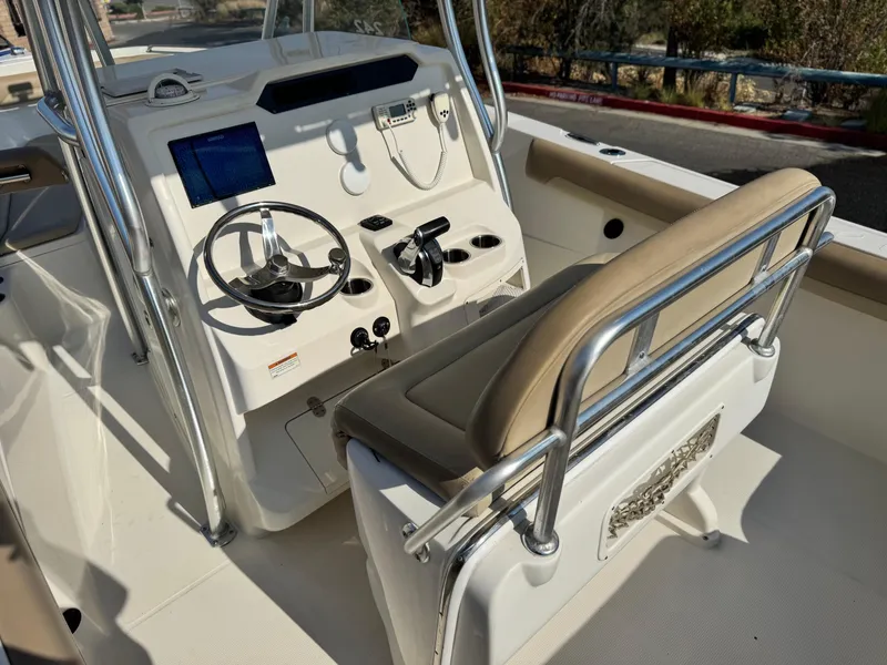 Slide: The Image of 2021 Sailfish 242 CC boat cockpit with steering wheel and seating. - 23