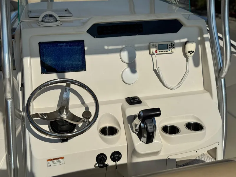 Slide: The Image of 2021 Sailfish 242 CC boat console with steering wheel, controls, and navigation equipment. - 24