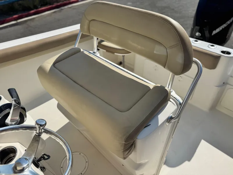 Slide: The Image of 2021 Sailfish 242 CC boat interior with beige seating and steering wheel. - 25