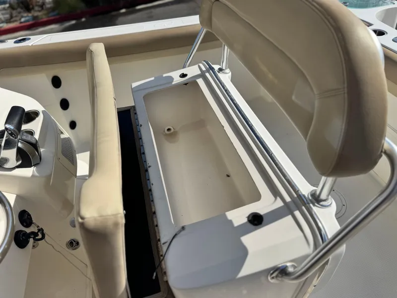 Slide: The Image of 2021 Sailfish 242 CC boat interior with beige seating and storage compartment. - 26