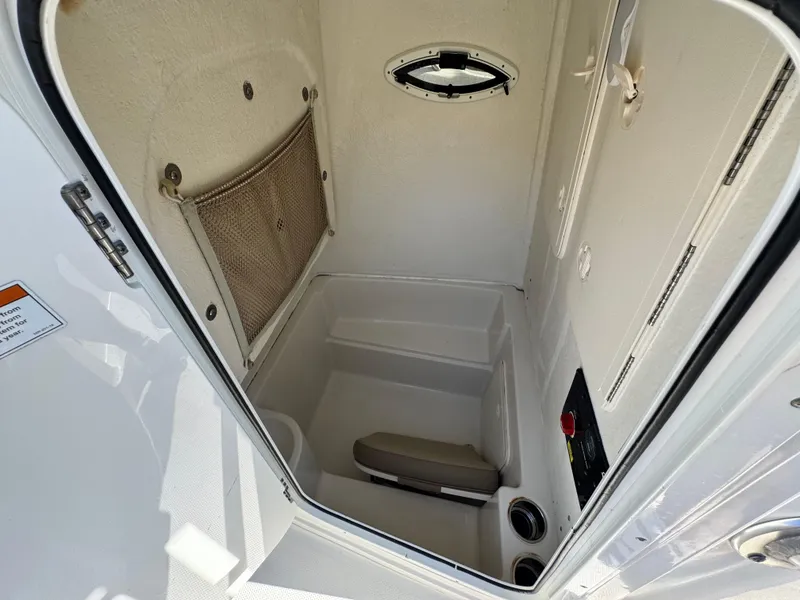 Slide: The Image of Interior of 2021 Sailfish 242 CC boat, featuring compact storage and seating area. - 28