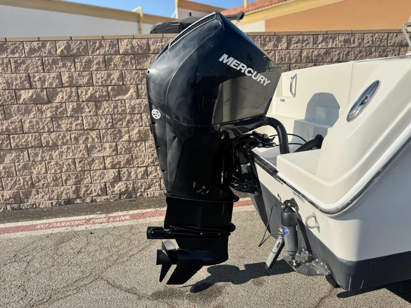 Slide: The Image of 2021 Sailfish 242 CC boat with Mercury outboard motor, parked on pavement. - 6