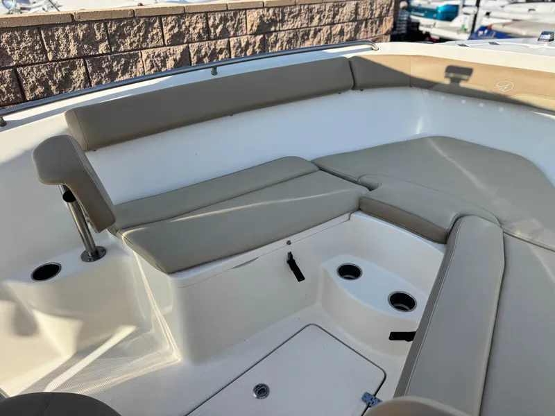 Slide: The Image of 2021 Sailfish 242 CC boat interior with beige seating and cup holders. - 9