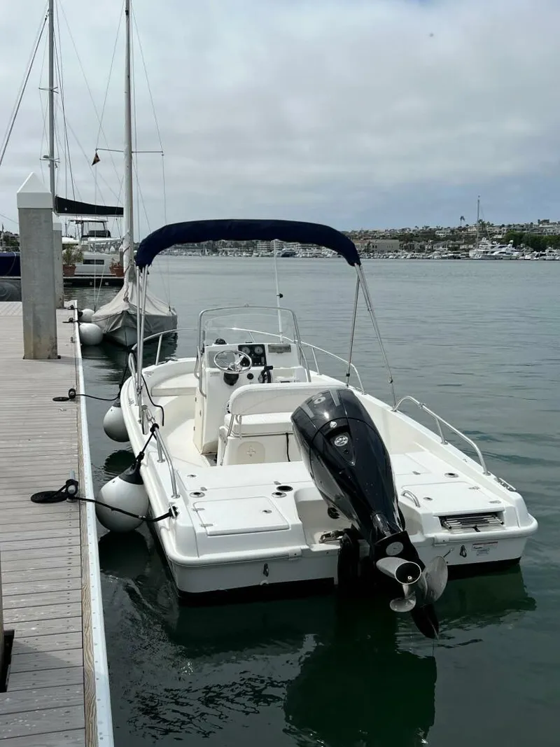 Slide: The Image of 2016 Boston Whaler 180 Dauntless boat docked at marina with outboard motor. - 5