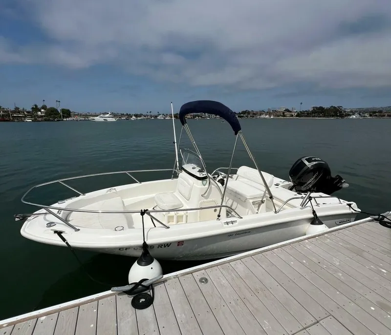 Slide: The Image of 2016 Boston Whaler 180 Dauntless boat docked on calm water. - 6