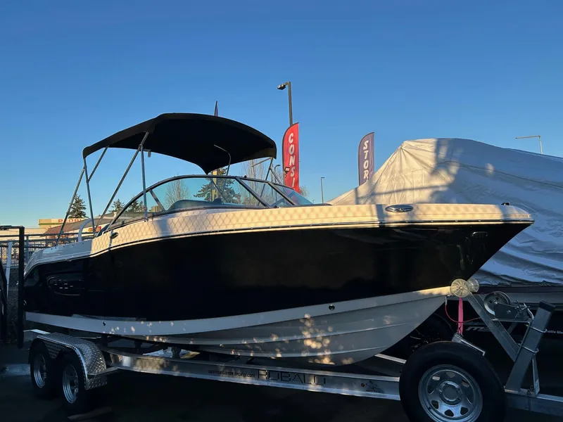The Image of 2026 Robalo R207 Dual Console boat on trailer, under clear blue sky. - 0