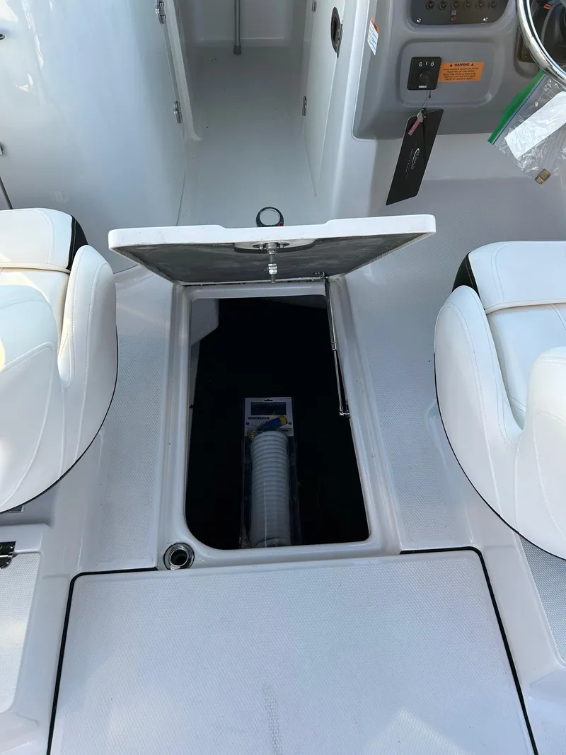 Slide: The Image of 2026 Robalo R207 Dual Console boat interior with open storage compartment. - 18