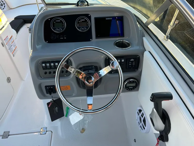 Slide: The Image of 2026 Robalo R207 Dual Console boat dashboard with steering wheel and control panel. - 21