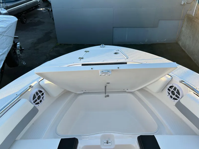 Slide: The Image of 2026 Robalo R207 Dual Console boat with open storage compartment and speakers. - 25