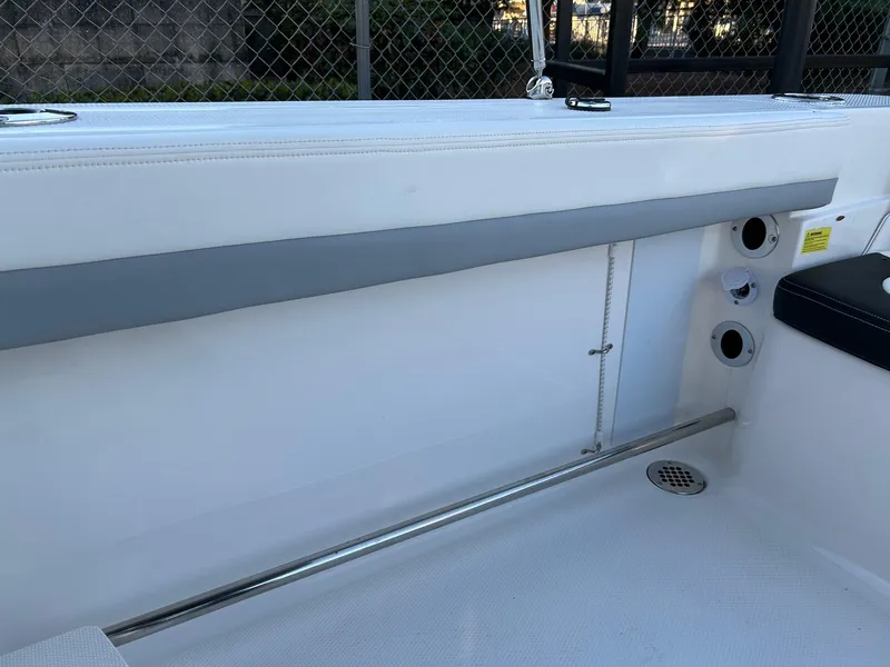 Slide: The Image of 2026 Robalo R207 Dual Console interior with white seating and stainless steel accents. - 28