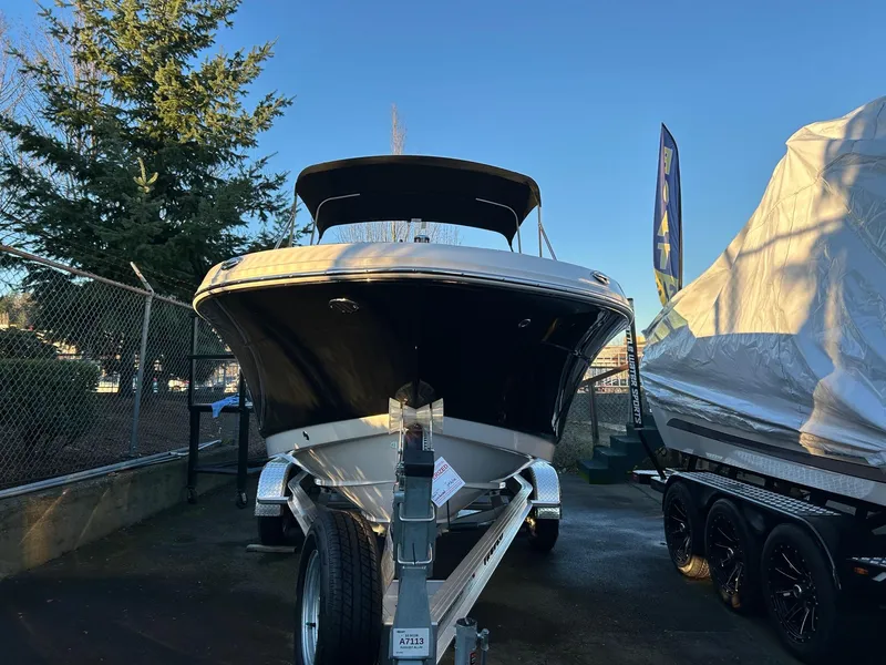 Slide: The Image of 2026 Robalo R207 Dual Console boat on trailer, parked outdoors under clear sky. - 33