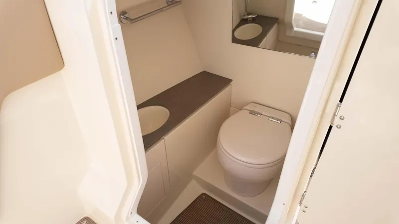 Slide: The Image of 2025 Chris-Craft Launch 28 GT boat bathroom with toilet, sink, and mirror. - 23
