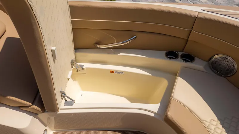 Slide: The Image of 2025 Chris-Craft Launch 28 GT interior storage compartment with beige seating and cup holders. - 27