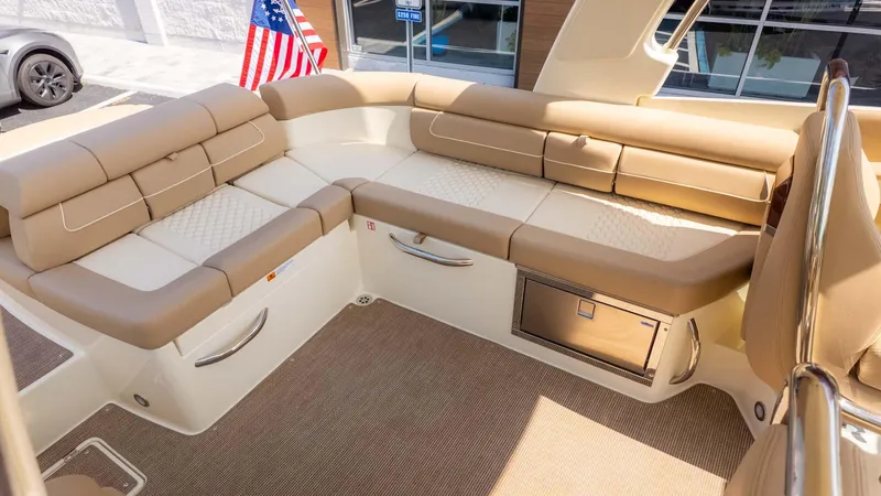 Slide: The Image of 2025 Chris-Craft Launch 28 GT interior with beige seating and American flag. - 9