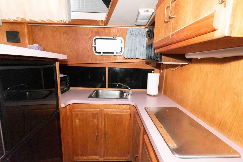 Slide: The Image of 1988 Mainship 36 Double Cabin kitchen with wood cabinets and sink. - 10