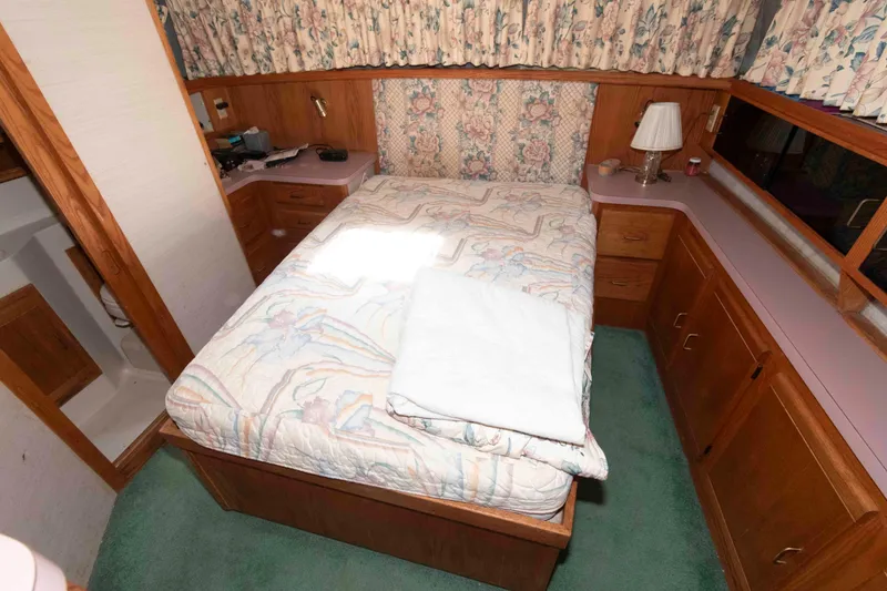 Slide: The Image of 1988 Mainship 36 Double Cabin bedroom with floral decor and wooden cabinetry. - 11