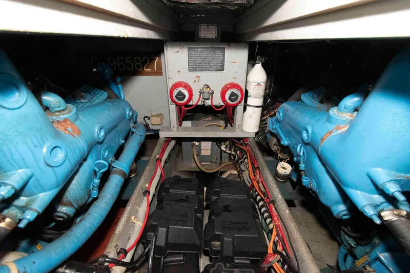 Slide: The Image of Engine room of 1988 Mainship 36 Double Cabin with blue engines and wiring. - 14