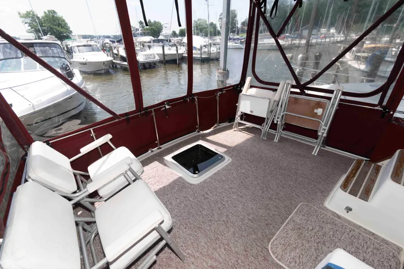 Slide: The Image of 1988 Mainship 36 Double Cabin interior with chairs, carpet, and marina view. - 4