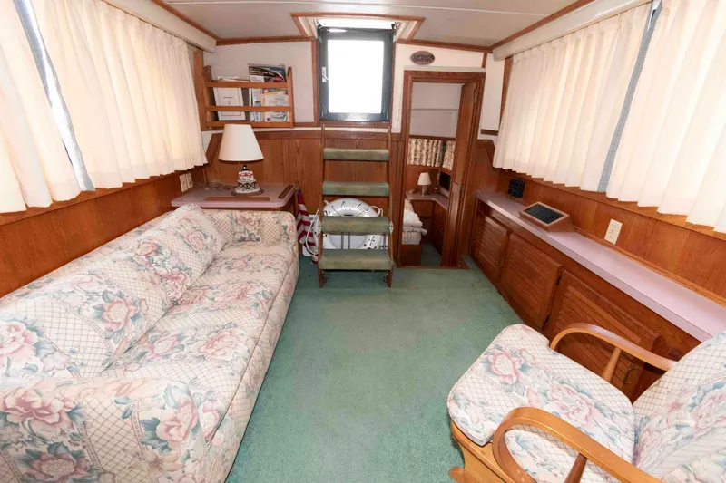Slide: The Image of Interior of 1988 Mainship 36 Double Cabin with floral sofa, chairs, and wood paneling. - 7