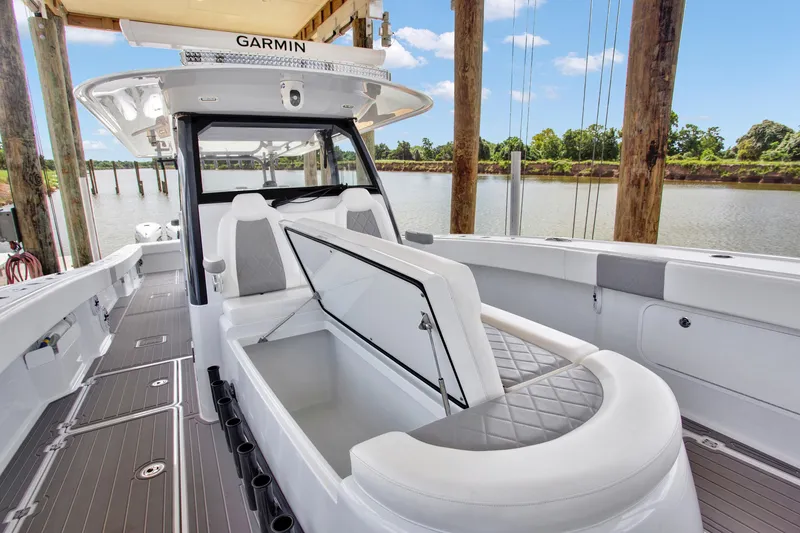 Slide: The Image of 2022 Freeman 47 boat interior with seating and storage, docked by a scenic river. - 34