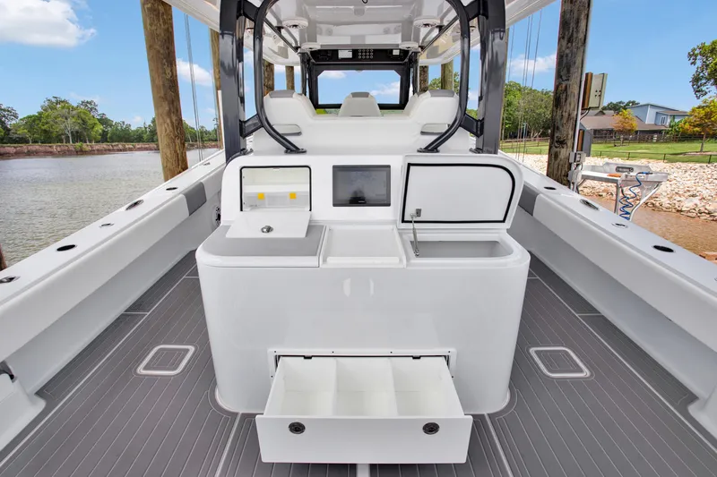 Slide: The Image of 2022 Freeman 47 boat interior with modern console and storage, docked by a scenic river. - 36