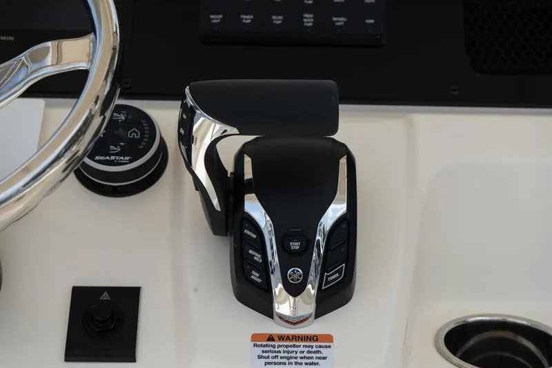 Slide: The Image of 2026 Scout 215 XSF boat control panel with steering wheel and throttle lever. - 10