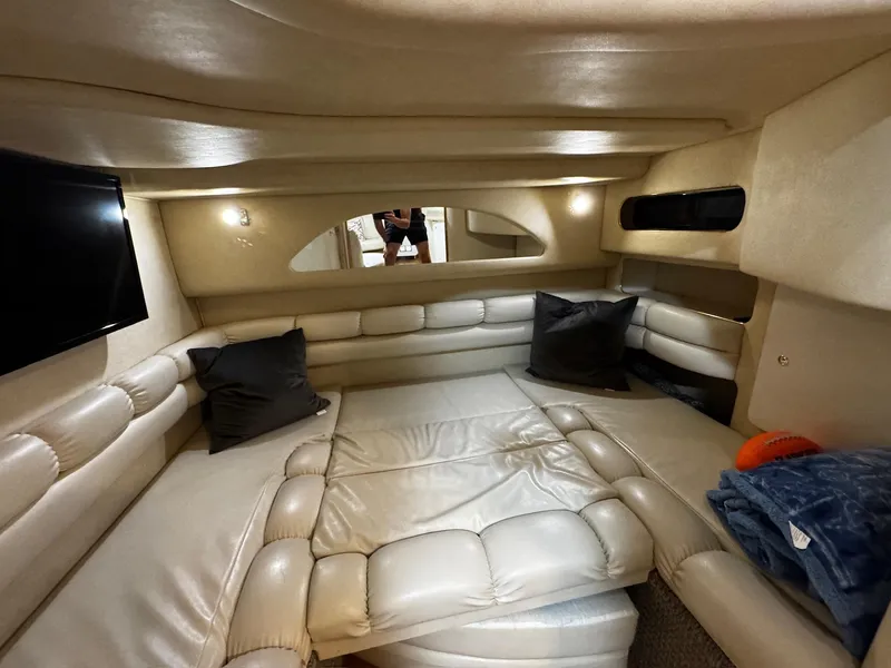 Slide: The Image of Interior of 1997 Sea Ray 400 Sundancer yacht with plush seating and TV. - 16