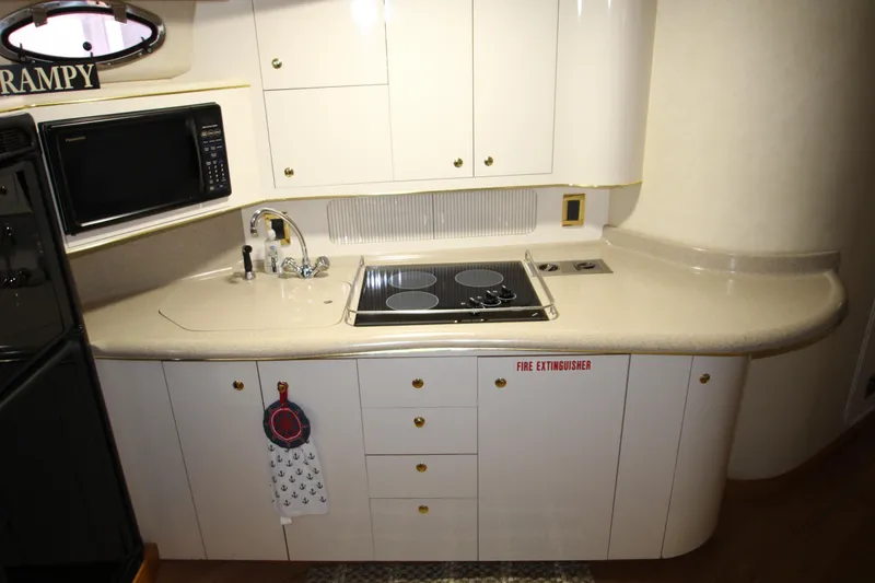 Slide: The Image of Interior of 1997 Sea Ray 400 Sundancer yacht kitchen with stove, sink, and cabinets. - 18