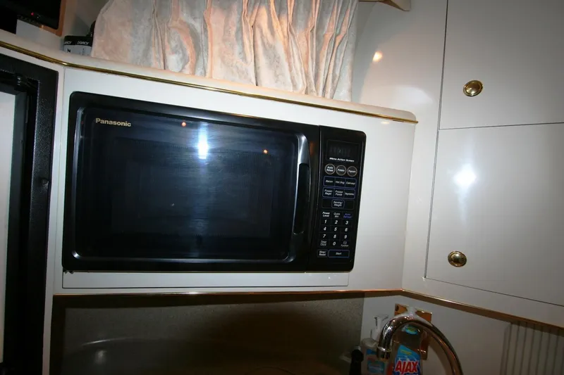 Slide: The Image of 1997 Sea Ray 400 Sundancer kitchen with modern stovetop and sleek cabinetry. - 21