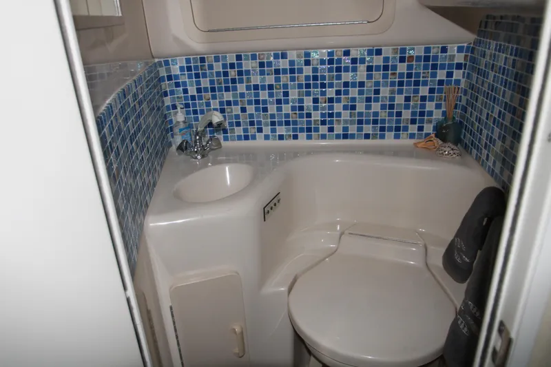 Slide: The Image of 1997 Sea Ray 400 Sundancer bathroom with mosaic tiles and porthole window. - 24