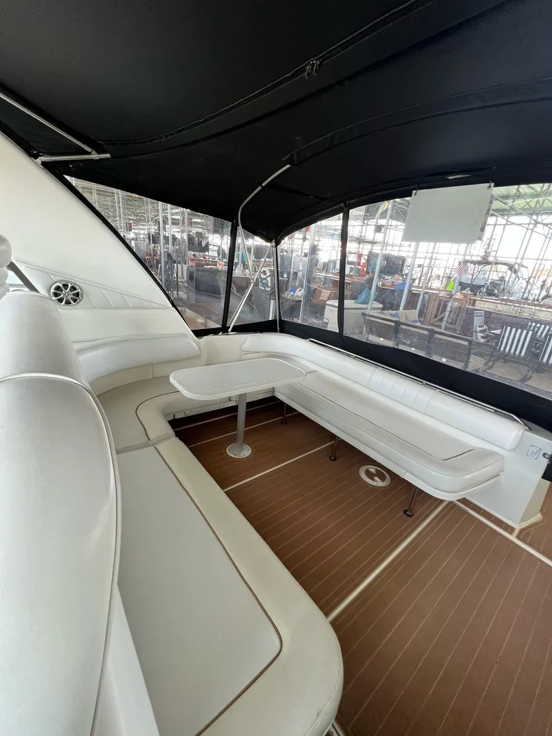 Slide: The Image of 1997 Sea Ray 400 Sundancer interior with white seating and wooden flooring. - 33